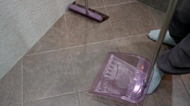 Süpürge ve faraşla yerleri süpüren kişi. Evin içini temizlemek ve hijyeni korumak..