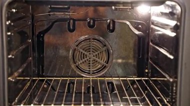 Pasta hamuruyla tavayı önceden ısıtılmış fırına koyan kadın. Ev mutfağındaki pişirme hazırlama sürecinin yakın görüntüsü.