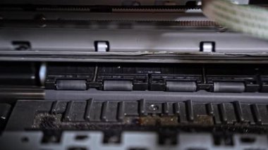 Aygıt başlatılırken dönen mürekkep püskürtme yazıcılarının yakın görüntüsü. Ofis içinde dönen kağıt besleme mekanizması.