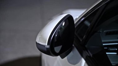 Arabanın yan aynasının yakın görüntüsü elektirik kontrolü kullanılarak katlanıp açılır. Dış ayna mekanizması araç kapısının yanında çalışıyor.