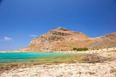 2019, 4 Haziran: - GREECE, CRETE Adası, GramvOUSA - Dağın tepesindeki kale ve altındaki plajdaki insanlar.