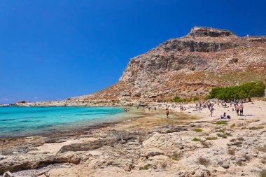 2019, 4 Haziran: - GREECE, CRETE Adası, GramvOUSA - Dağın tepesindeki kale ve altındaki plajdaki insanlar.