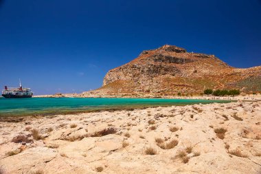 2019, 4 Haziran: - GREECE, CRETE Adası, GramvOUSA - Dağın tepesindeki kale ve altındaki plajdaki insanlar.