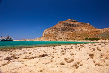 2019, 4 Haziran: - GREECE, CRETE Adası, GramvOUSA - Dağın tepesindeki kale ve altındaki plajdaki insanlar.