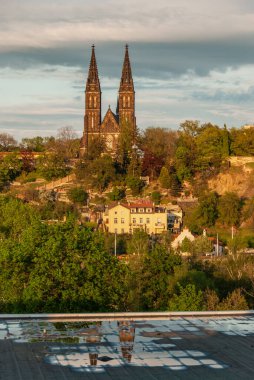 Çek Cumhuriyeti Prag 'daki Vysehrad Kalesi ve Aziz Peter Bazilikası manzarası bir su birikintisine yansıdı. 
