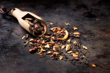 Kurutulmuş Masala Chai Black Tea yaprakları koyu dokulu arka plan afişinde. Uzayı kopyala Seçici odak.