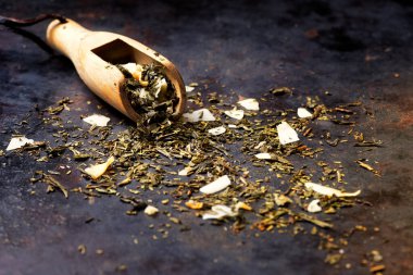 Hindistan cevizi talaşı, ananas ve narenciye aromalı koyu dokulu arka plan pankartıyla tatlandırılmış Sencha yeşil çayı. Pina Colada çayı. Seçici odaklanma. Boşluğu kopyala.