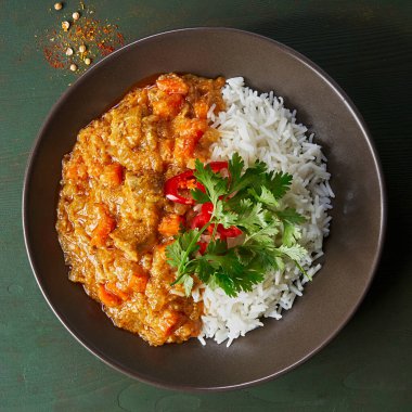 Tavuklu tikka masala baharatlı körili et yemeği marber tabağında pilav ve koyu gri arka planda baharatlar. Hint yemeği tarifi. Kapatın. Üst görünüm.