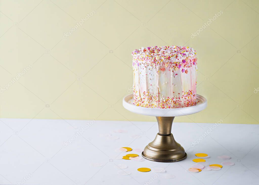 Yellow buttercream ombre birthday cake with colorful sprinkles over yellow background with copy space. Romantic love concept. Valentine's, Mother's Day, Birthday Cake card Background, Close Up.