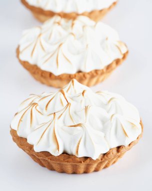 Beyaz arka planda Lemon Curd ve Meringue Mini Turtaları, seçici odak, metin için boşluk. Pasta pastası tatlı konsepti.