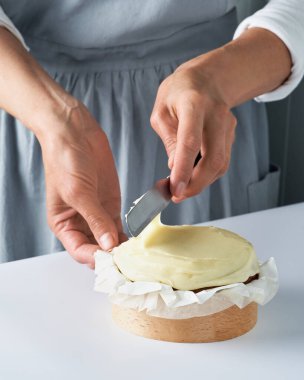 Şekerci kadınlar iş başında. Kremalı pasta dekorasyonu. Kapatın. Yemek masası pasta hazırlıyor. Ev yapımı pasta, kek pişirme konsepti..