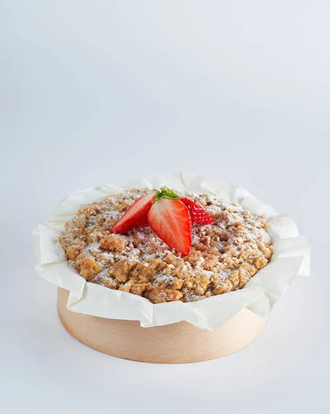 Baked strawberry mini crumble cake on recycle Mini Wooden Baking Mold, white background, space for text, selective focus. Homemade pastry, cooking cakes concept.