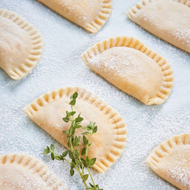 Çiğ Empandilla, küçük dolgulu ton balığı turtası, domates sosu, dolma biber, haşlanmış yumurta. Fırında pişmeden önce. Yemek pişirme süreci. Akdeniz İspanyol yemekleri. Kapatın. Seçici odak.