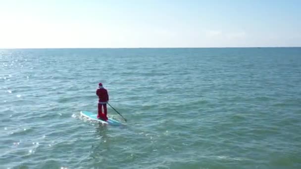 Tomten Med Presentpåse Surfing Tomten Surfbräda Havet Människan Sportar Tomtedräkt — Stockvideo