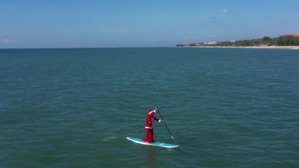 Święty Mikołaj Torbą Prezentów Surfingu Mikołaj Desce Surfingowej Morzu Facet — Wideo stockowe