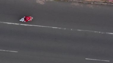 Noel Baba 'dan Noel Baba' ya beyaz motosikletle hediye paketi ve hediye paketi ile yaz günbatımında. Yeni yıl ve Noel içeriği. Noel Baba kostümlü çocuk bisiklete biniyor. 