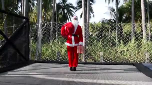 Kerstman Springt Een Trampoline Met Een Tas Met Cadeaus Een — Stockvideo