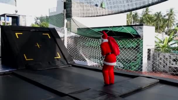 Der Weihnachtsmann Hüpft Auf Einem Trampolin Mit Einem Sack Voller — Stockvideo