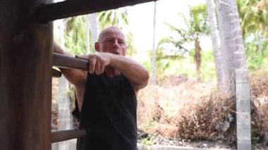 Kung fu ustası alıştırması yapıyor. Kung fu ustası, sensei, öğretmen, yetişkin adam simülatörde ustalaşıyor. Adam kung fu çalışıyor. Yakın plan, yetişkin bir adamın portresi.