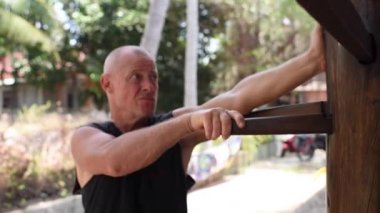 Kung fu ustası alıştırması yapıyor. Kung fu ustası, sensei, öğretmen, yetişkin adam simülatörde ustalaşıyor. Adam kung fu çalışıyor. Yakın plan, yetişkin bir adamın portresi.