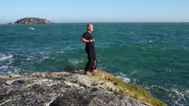 Starzec Czerni Sensei Wybrzeżu Zaangażowany Kung Meditaion Plaży Oceanicznej Kamiennym — Wideo stockowe