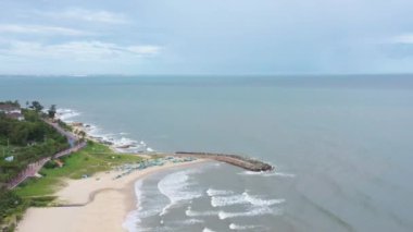 İnsansız hava aracı dalgaların ve balıkçı teknelerinin üzerinden boş kumsalın üzerinde uçuyor. Yakında yağmur başlayacak. Vietnam 'da güzel deniz manzarası