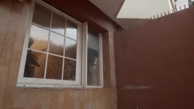 Bir adam aksiyon sahnesi için pencereden ağır çekimde atlıyor.