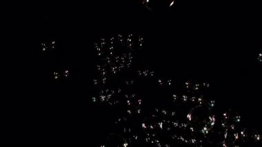 Gerçek sabun köpükleri siyah arka planlı kamera lensine doğru geliyor.