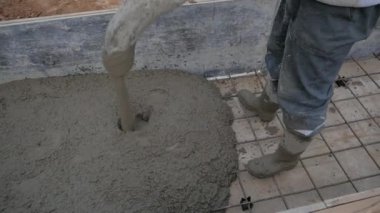 İnşaat işçileri inşaat alanında vinç ya da beton pompa vinç kullanarak ıslak beton döküyorlar..