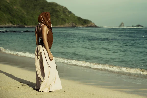 Young woman in summer dress standing by blue sea — Stock Photo, Image