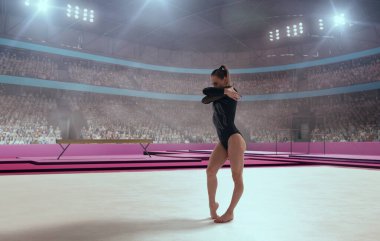 Bir jimnastikçi denge aletinde zor bir numara yapar..