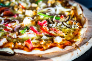 Biberli, peynirli, kırmızı ve yeşil dolmalık biberli, mantarlı ince hamurlu pizza.