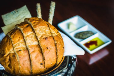 Bir somun ekmek hanı keten, zeytinyağı ve tereyağı dolu bir sepet.