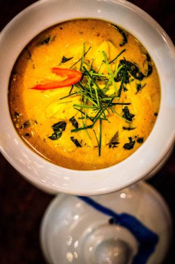 Tayland yeşili köri, tavuk ve otlarla süslenmiş ve beyaz bir kasede servis ediliyor.