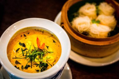 Tayland yeşili köri, tavuk ve otlarla süslenmiş ve beyaz bir kasede servis ediliyor.