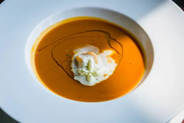 Bir tabak krema ve küçük karideslerle süslenmiş ıstakoz çorbası.