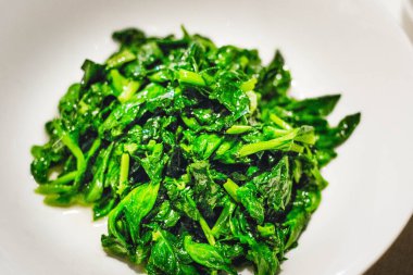 yeşil sebzeler Çin usulü kızartılmış ve beyaz tabakta servis ediliyor.