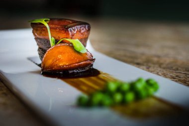 Shanghaiese ağır ateşte pişirilmiş domuz eti (Dong Po eti) ve yanında da Gorgon Fruit ile sotelenmiş tatlı bezelye.