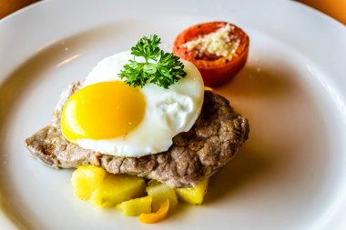 Sığır filetosu biftek kızarmış yumurta ve kahvaltı patates ile tepesinde