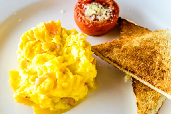 Mjuk äggröra med rökt lax. Serveras med grillad tomat och vete toast. — Stockfoto