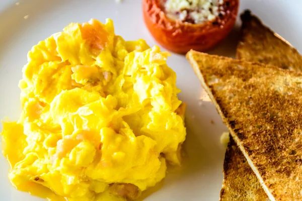 Mjuk äggröra med rökt lax. Serveras med grillad tomat och vete toast. — Stockfoto