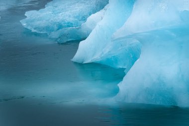 Jokulsarlon Buzul Gölü, Vatnajokull Ulusal Parkı, İzlanda. Okyanus körfezi ve buzdağları. Yaz sezonu. Doğal İzlanda manzarası. Su yüzeyinde yansıma. Seyahat ve tatil