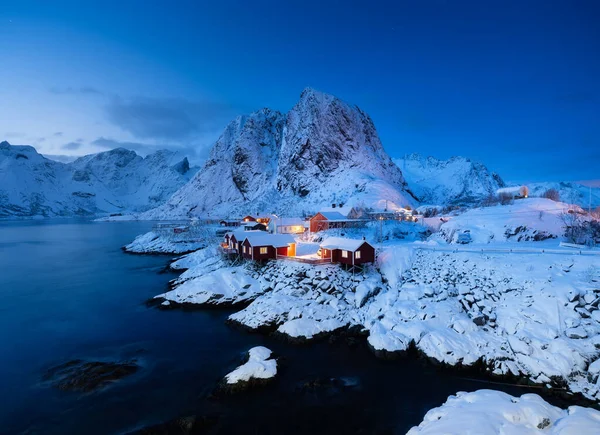 Iconic view in Norway after sunset. View on the houses in the Hamnoy village, Lofoten Islands, Norway. Landscape in winter time during blue hour. Mountains and water. Travel Norway image