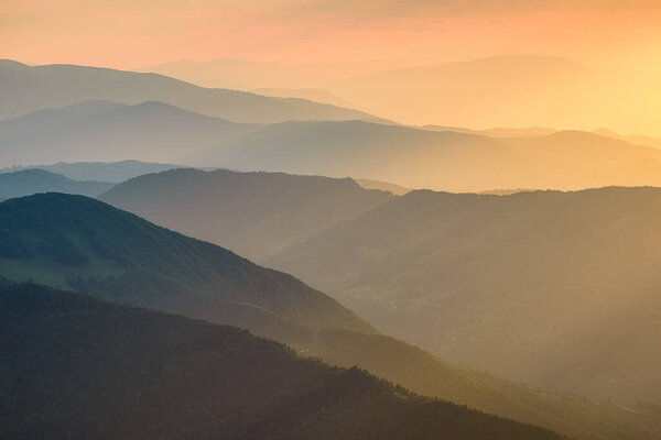 Mountains during sunset. Lines of mountain slopes during sunset. Fog in the mountains. Sunlight. Natural landscape in the summertime.