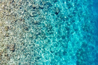 Akdeniz 'de. Su ve kayaların hava manzarası. Şeffaf su. Tatil ve macera. Kumsal ve mavi su. Kumsaldaki ve mavi denizdeki İHA 'nın üst görüntüsü.