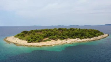 Hırvatistan. Su ve kayaların hava manzarası. Tatil ve macera. Kumsal ve mavi su. Kumsaldaki ve mavi denizdeki İHA 'nın üst görüntüsü.