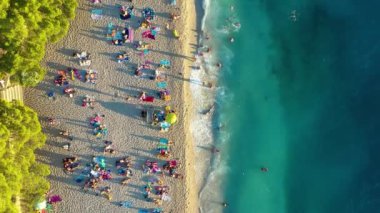 Hırvatistan. Sahildeki hava manzarası. Tatil ve macera. Kumsal ve mavi su. Kumsaldaki ve gök mavisi denizdeki İHA 'nın üst görüntüsü. Seyahat ve tatil videosu.