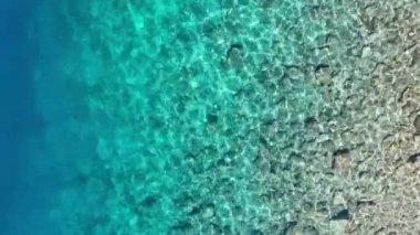 Arka plan olarak dalgalar ve gök mavisi su. Okyanus yüzeyindeki insansız hava aracının görüntüsü. Doğal yaz deniz manzarası. Su videosu arkaplanı.