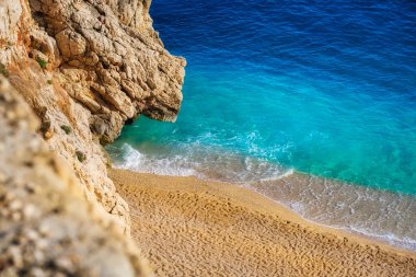 Sahildeki hava manzarası. Tatil ve macera. Kumsal ve mavi su. Kumsaldaki ve mavi denizdeki İHA 'nın üst görüntüsü. Seyahat ve tatil görüntüsü.