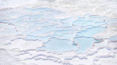 Travertinlerin manzarası. Pamukale, Türkiye. Teraslarda mavi su. Turizm için popüler bir yer. Beyaz kayalar ve su.